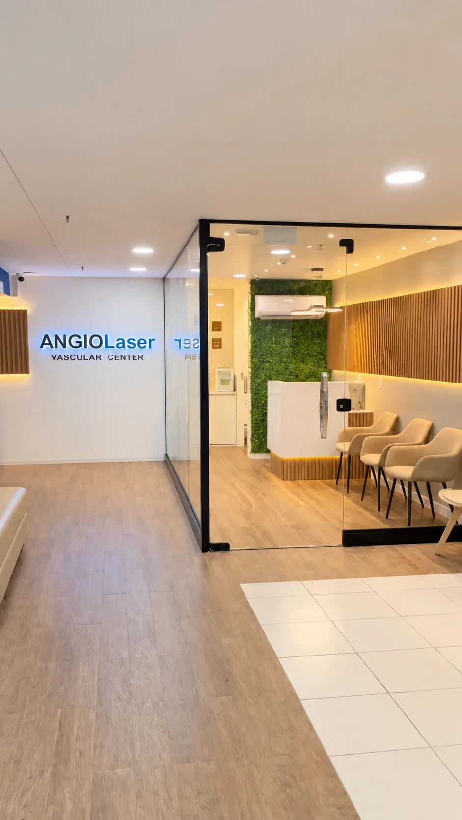 Recepção do consultório, com sala de espera confortável, painel de madeira e paredes com plantas